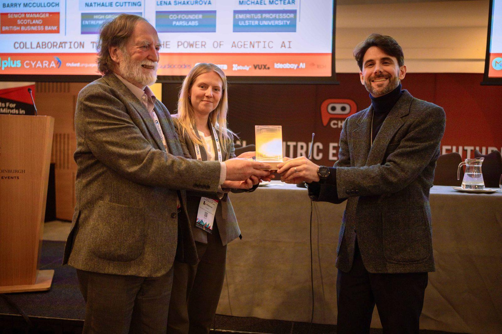 Lena on stage presenting a startup award at the European Chatbot & Conversational AI Summit